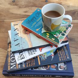 A stack of well-thumbed books beside a mug of coffee — the raw material of an ordinary morning's thinking.